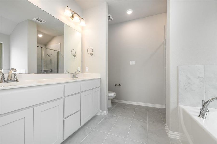 Full bathroom featuring dual vanity, plus walk in shower, tile patterned flooring, and toilet