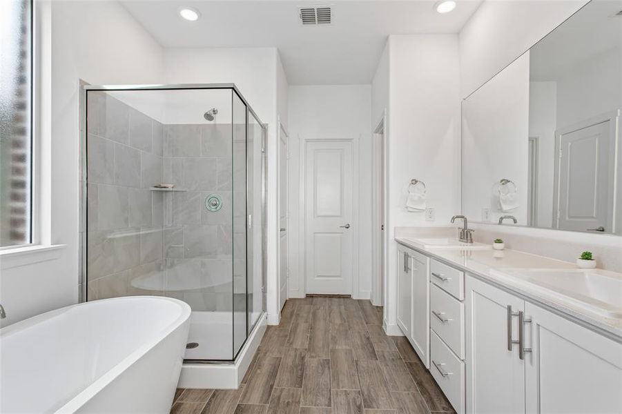 Modern bathroom featuring wood-finish flooring and a freestanding soaking tub