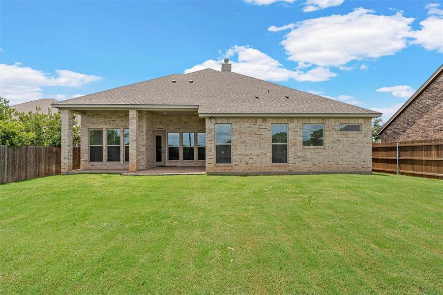 Expansive backyard with lush lawn and open green space beyond the fence line. Expansive backyard with lush lawn and open green space beyond the fence line.