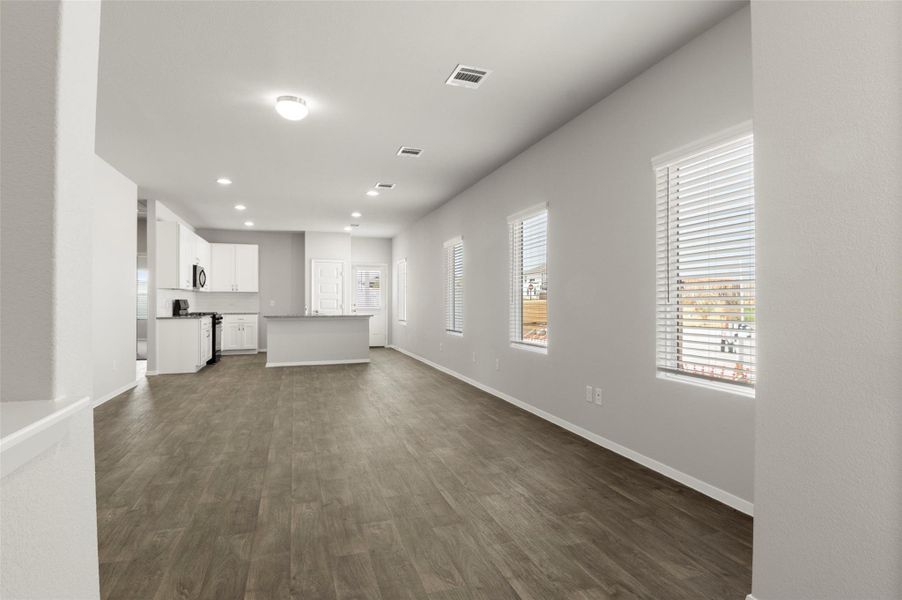 Unfurnished living room featuring dark wood finished floors and recessed lighting