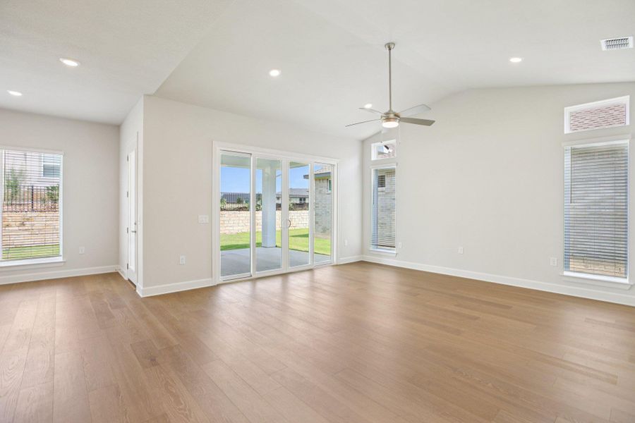 Empty room featuring light wood finished floors, recessed lighting, a ceiling fan, and vaulted ceiling
