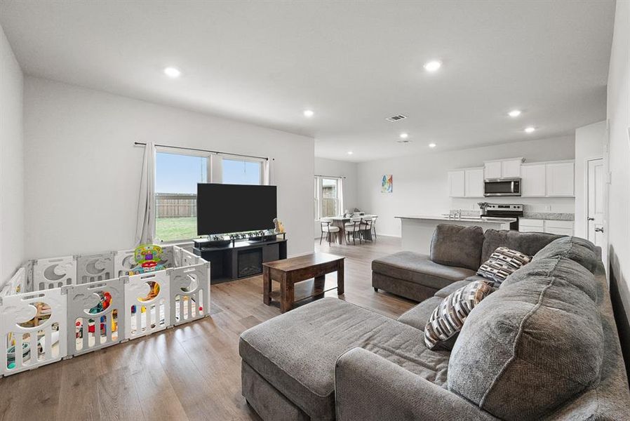 Open-concept living space featuring wood-finish flooring and recessed lighting throughout