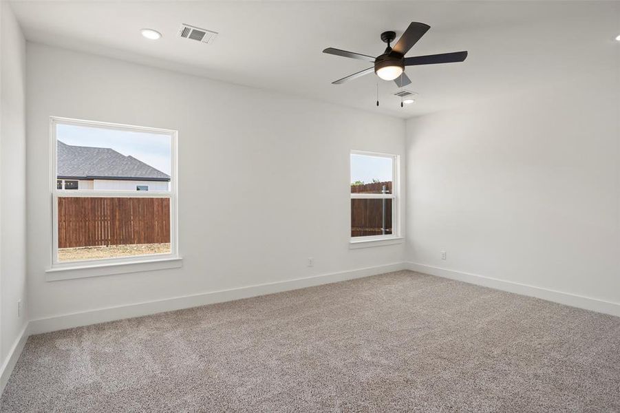 Carpeted spare room featuring ceiling fan