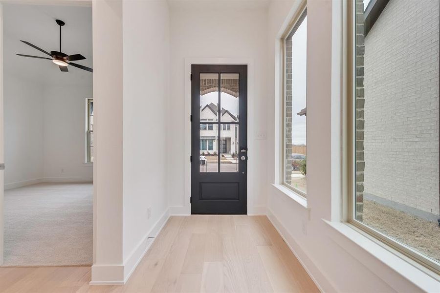 Foyer entrance featuring light wood-style flooring and baseboards Foyer entrance featuring light wood-style flooring and baseboards