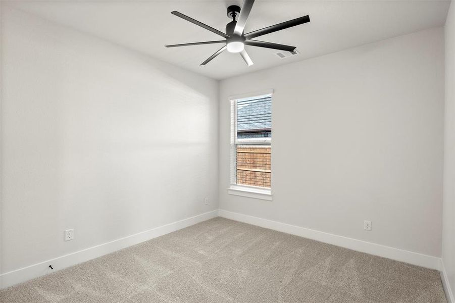 Empty room with carpet floors and ceiling fan