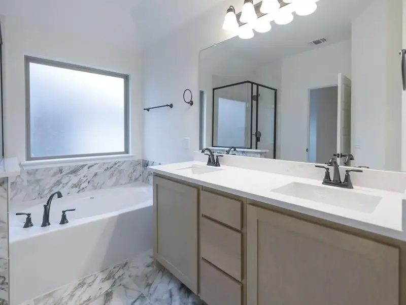 Bathroom featuring shower with separate bathtub, vanity, and vaulted ceiling