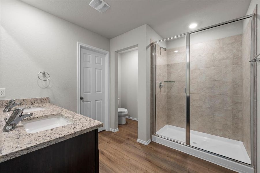 Full bathroom featuring double vanity, dark wood-style floors, a shower stall, and recessed lighting Full bathroom featuring double vanity, dark wood-style floors, a shower stall, and recessed lighting