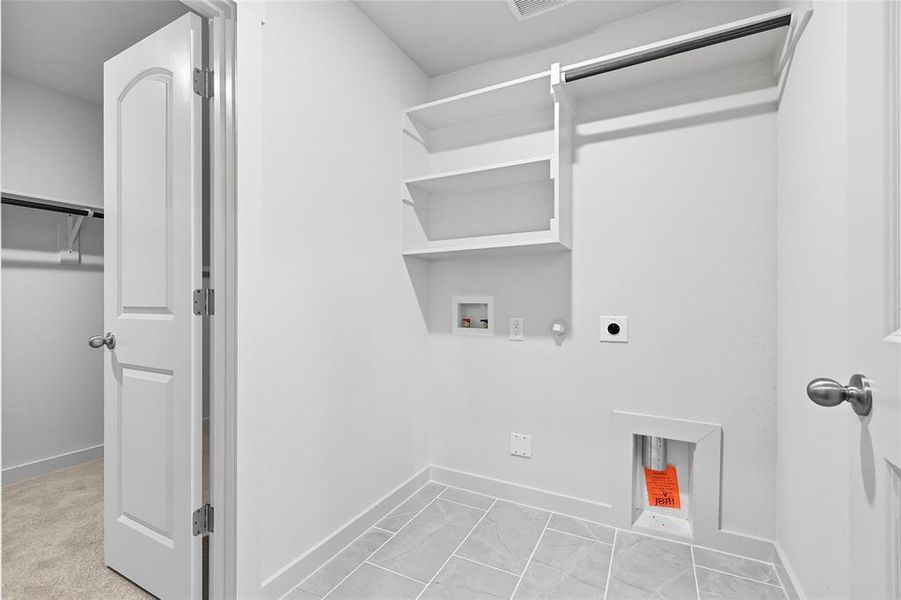 Laundry room featuring hookup for a gas dryer, washer hookup, and electric dryer hookup Laundry room featuring hookup for a gas dryer, washer hookup, and electric dryer hookup