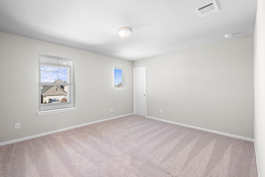 Your secondary bedroom features plush carpet, fresh paint, closet, and a large window that lets in plenty of natural lighting.