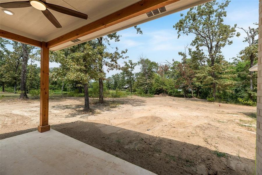 View of yard featuring a ceiling fan and a patio