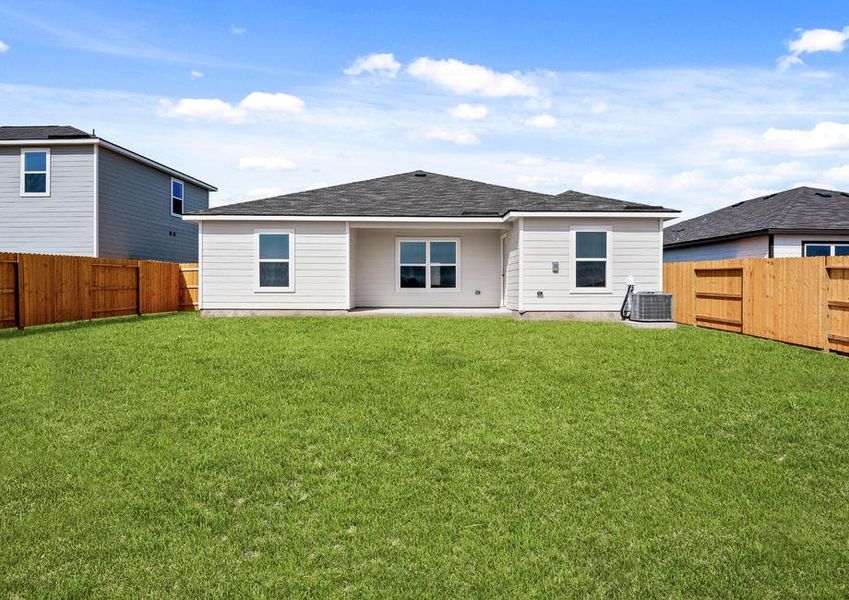 A fenced backyard with a covered patio