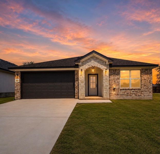 An inviting entry framed by a stone archway welcomes you to this classic brick home, set against a fiery sunset. An inviting entry framed by a stone archway welcomes you to this classic brick home, set against a fiery sunset.