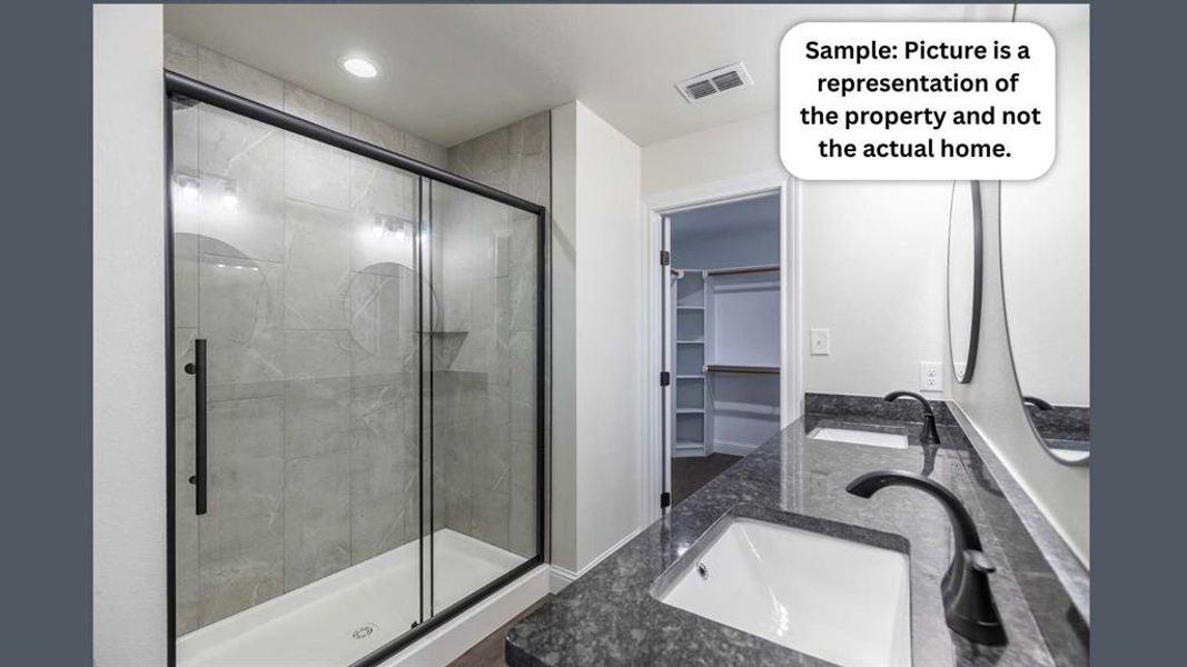 Bathroom with a spacious closet, double vanity, a shower stall, and recessed lighting