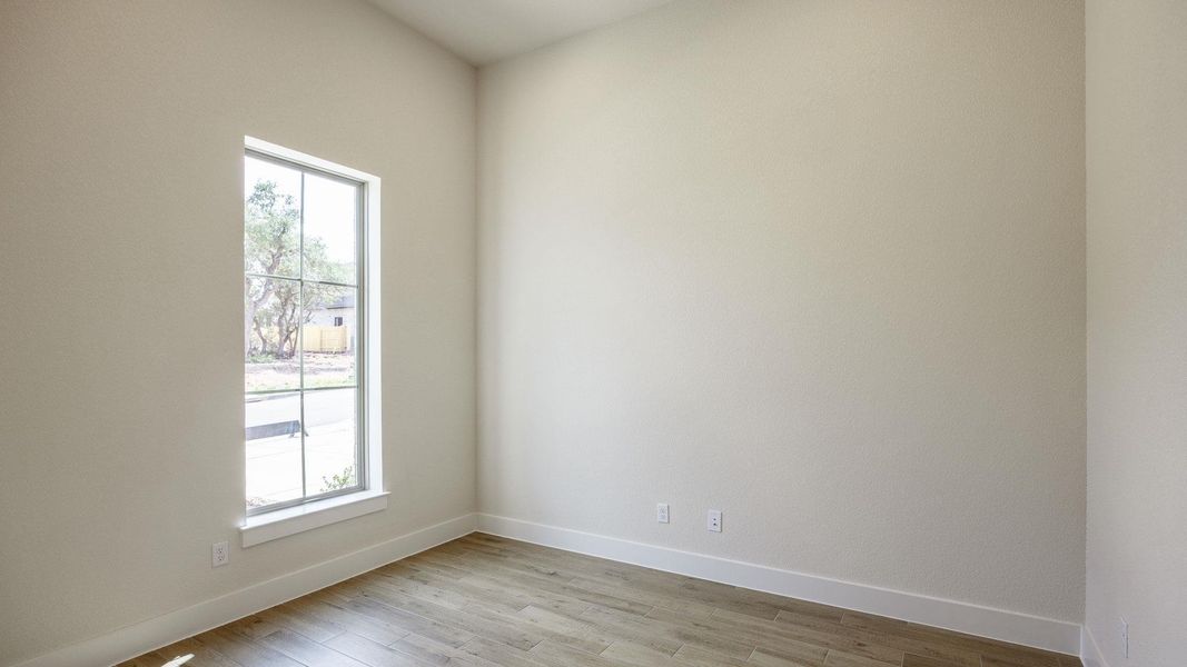 Unfurnished room with healthy amount of natural light, light wood-type flooring, and baseboards Unfurnished room with healthy amount of natural light, light wood-type flooring, and baseboards