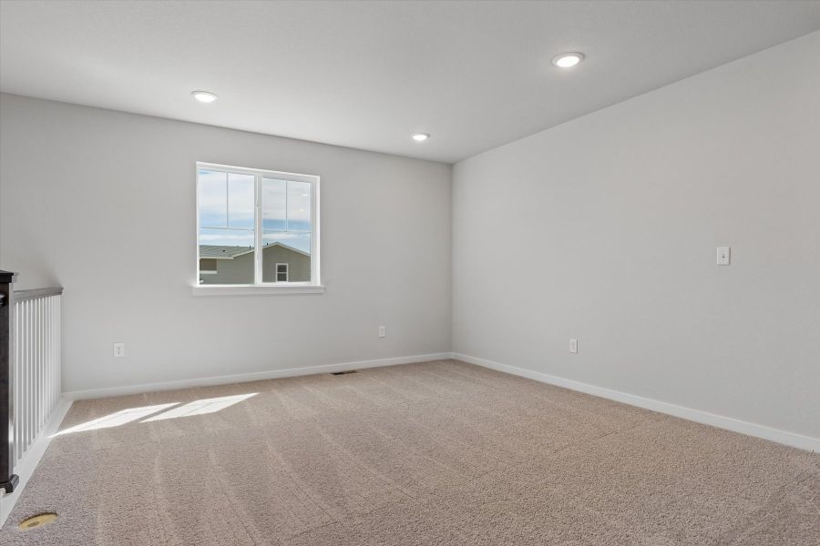 A room with a carpet and a window.