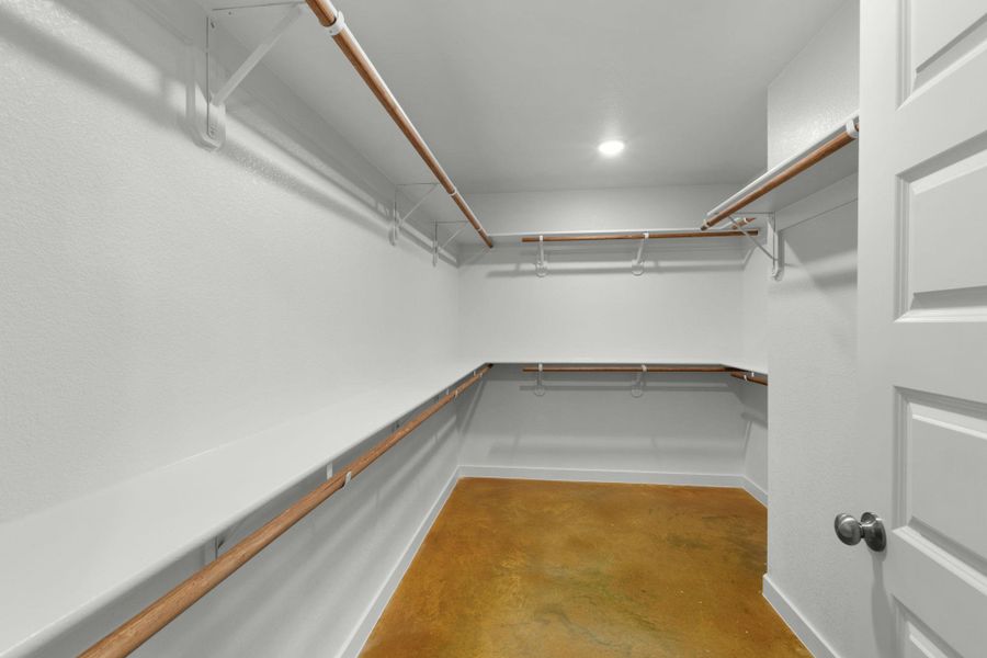 Ample hanging space and shelving offer ultimate organization in this spacious walk-in closet.