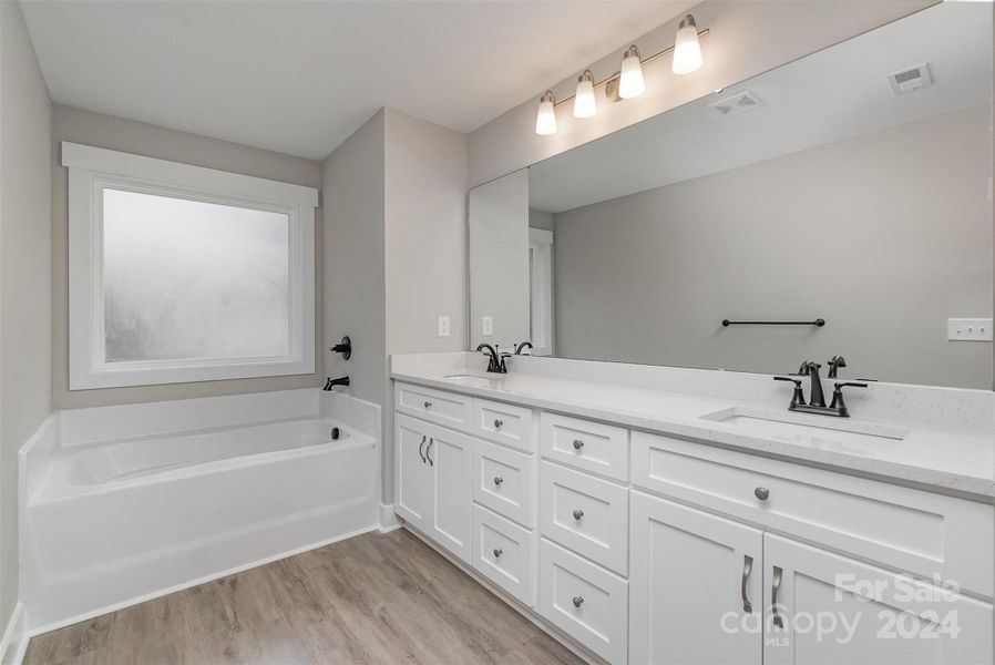 Beautiful Primary Bath with His/Her Vanities, Granite Counter Tops with Undermounted sinks, Soft Close Cabinetry, and Large Garden Tub