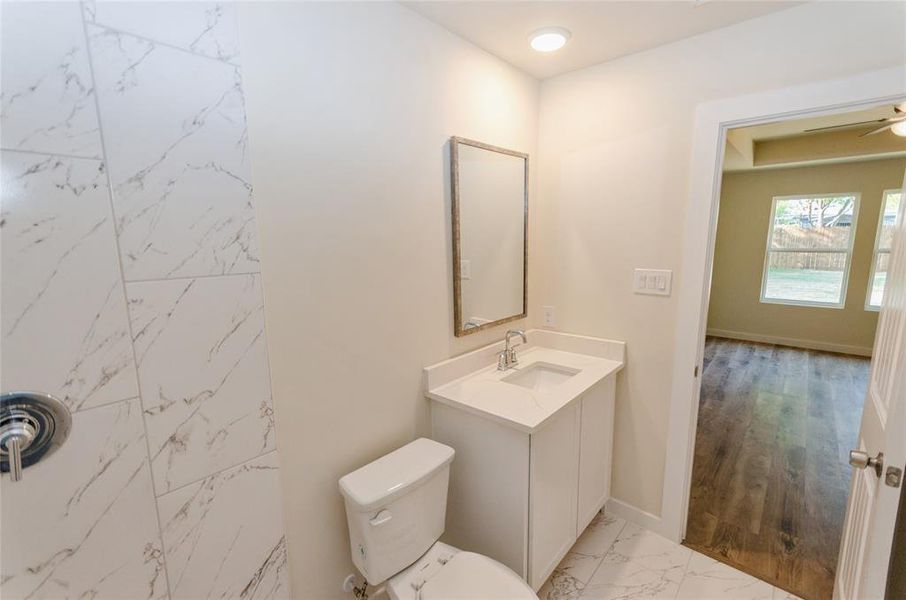 Bathroom with hardwood / wood-style flooring, vanity, and toilet