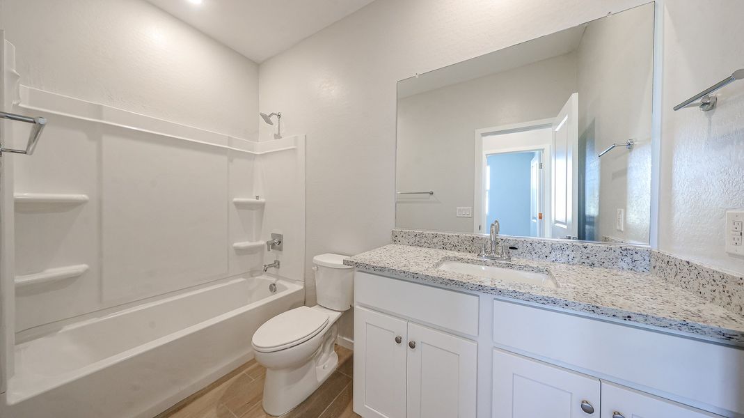 A bathroom with a tub sink and toilet.
