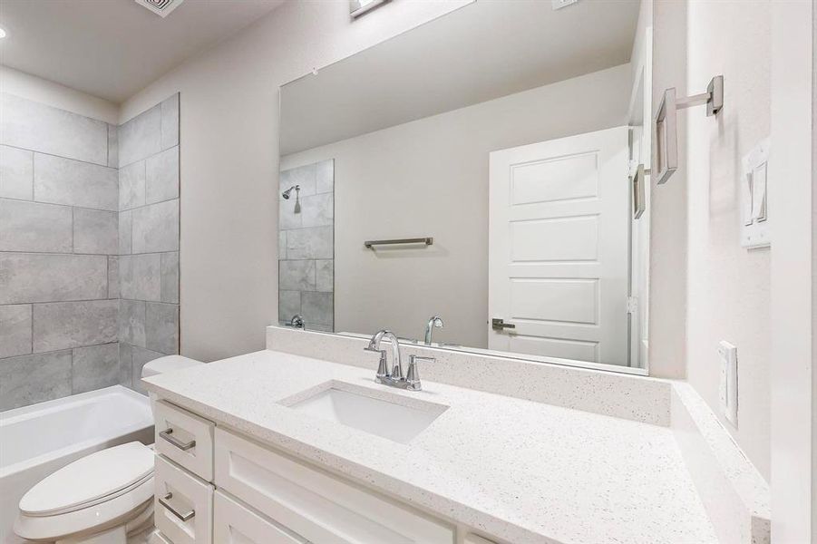 Full bathroom with vanity, toilet, and tiled shower / bath