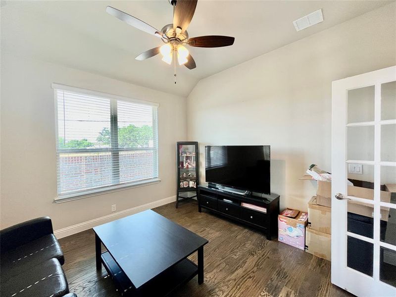 Living room featuring ceiling fan, vaulted ceiling, and dark hardwood / wood-style flooring