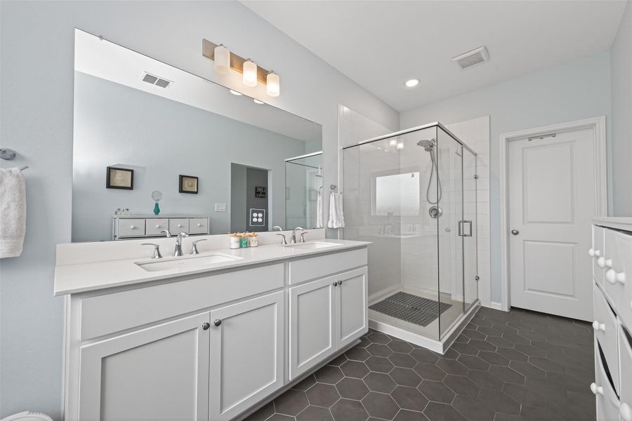 Bright primary bathroom with generous vanity space and a large stand-up glass-enclosed shower