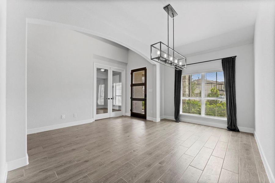 Home office with French doors and formal dining room frame elongated entry. Home office with French doors and formal dining room frame elongated entry.