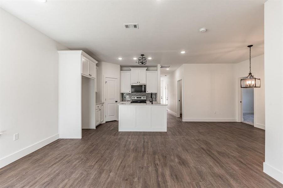 Kitchen with a kitchen island, dark hardwood / wood-style floors, white cabinets, and appliances with stainless steel finishes