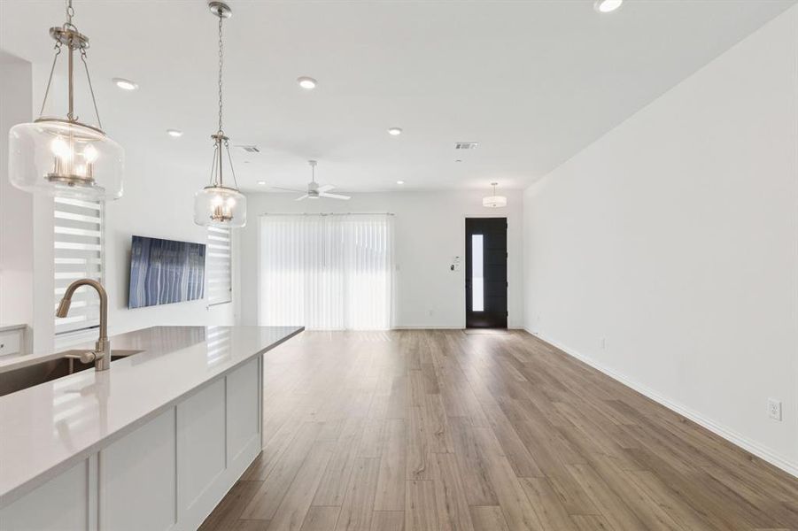 Kitchen with hanging light fixtures, open floor plan, white cabinets, light wood-style flooring, and recessed lighting Kitchen with hanging light fixtures, open floor plan, white cabinets, light wood-style flooring, and recessed lighting