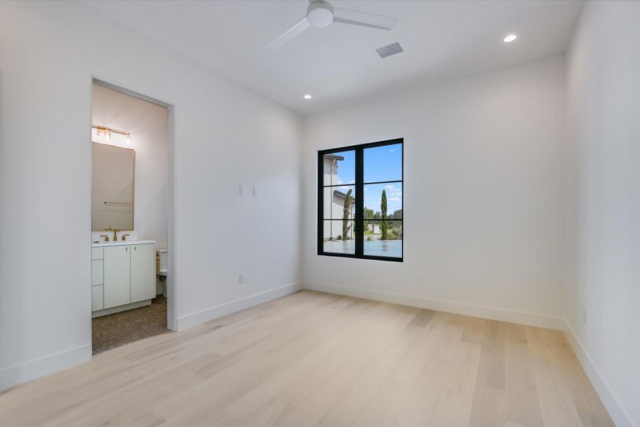 A well-lit room offers clean lines, a bright water view, and a convenient adjoining bathroom.