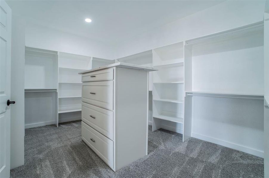 Walk in closet featuring dark colored carpet Walk in closet featuring dark colored carpet
