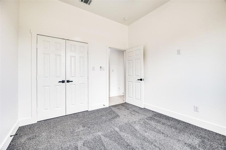 Unfurnished bedroom featuring carpet flooring and a closet Unfurnished bedroom featuring carpet flooring and a closet