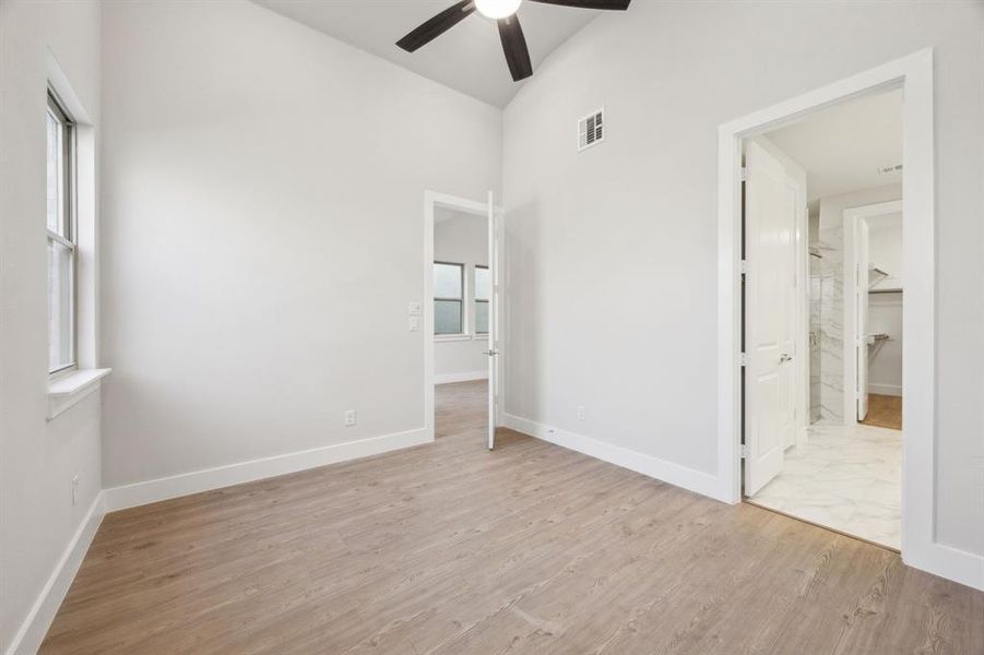 Primary bedroom with ceiling fan and light wood-type flooring