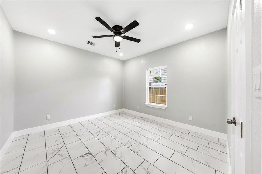 Empty room with marble look tiles, a ceiling fan, and recessed lighting