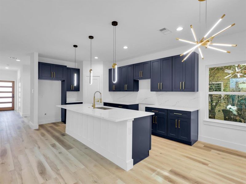 Kitchen with pendant lighting, light wood-type flooring, a wealth of natural light, and sink