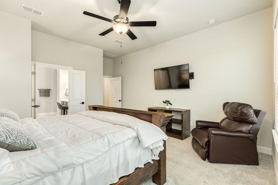 The spacious primary bedroom has double doors that open to a spa-like primary bath