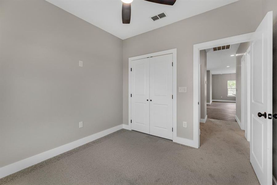 Unfurnished bedroom featuring a closet, ceiling fan, and carpet flooring