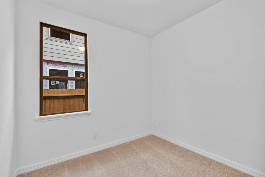 Perfect for family or guests—fourth bedroom with a walk-in closet and soft carpet underfoot.