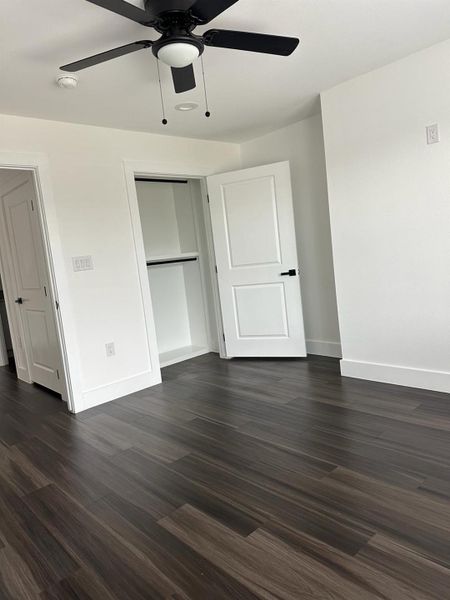 Unfurnished bedroom featuring dark wood finished floors and ceiling fan Unfurnished bedroom featuring dark wood finished floors and ceiling fan