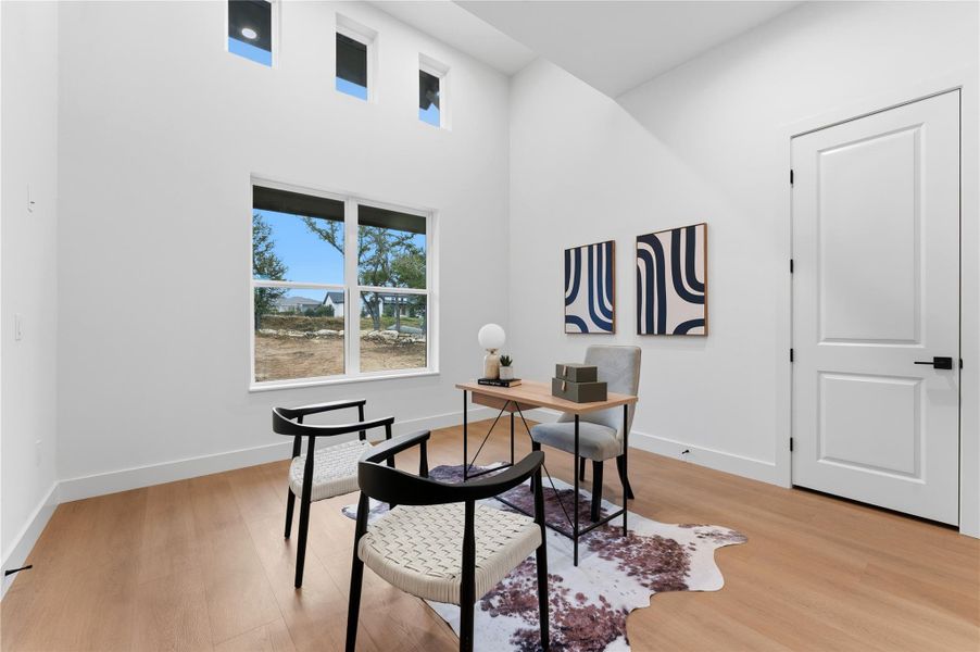 Office space featuring a high ceiling and light wood finished floors