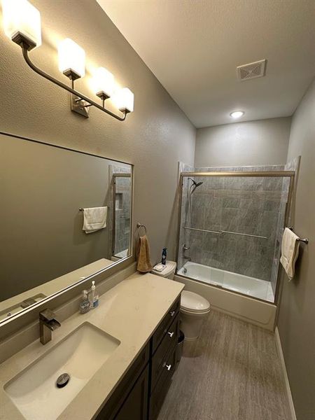 Bathroom with shower / bathtub combination, vanity, and dark wood finished floors