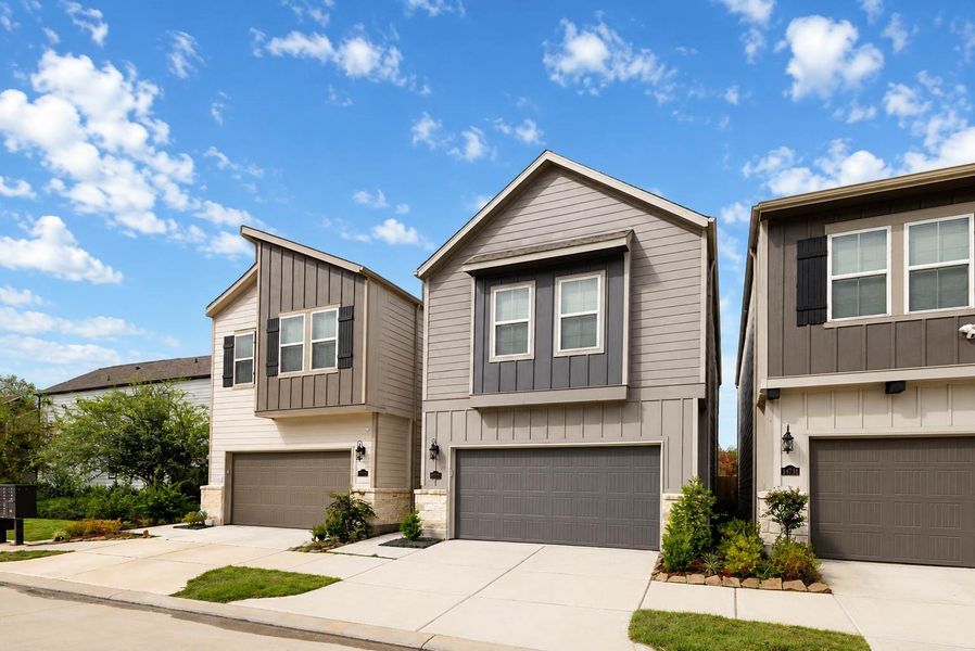 A striking modern exterior combines horizontal and board-and-batten siding, dark accent panels, stone details, and clean architectural lines. The attached two-car garage and private driveway offer everyday convenience, while thoughtfully placed landscaping adds warmth and curb appeal. A striking modern exterior combines horizontal and board-and-batten siding, dark accent panels, stone details, and clean architectural lines. The attached two-car garage and private driveway offer everyday convenience, while thoughtfully placed landscaping adds warmth and curb appeal.
