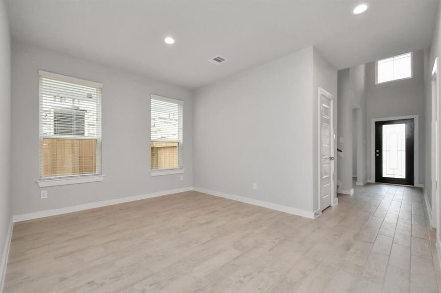 An inviting dining space adjacent to the kitchen for added convenience. Revel in the stunning floors, soothing paint palette, and the large windows with privacy blinds – a perfect setting for shared meals and cherished moments. Sample photo of completed home with similar plan. As built color and selections may vary.