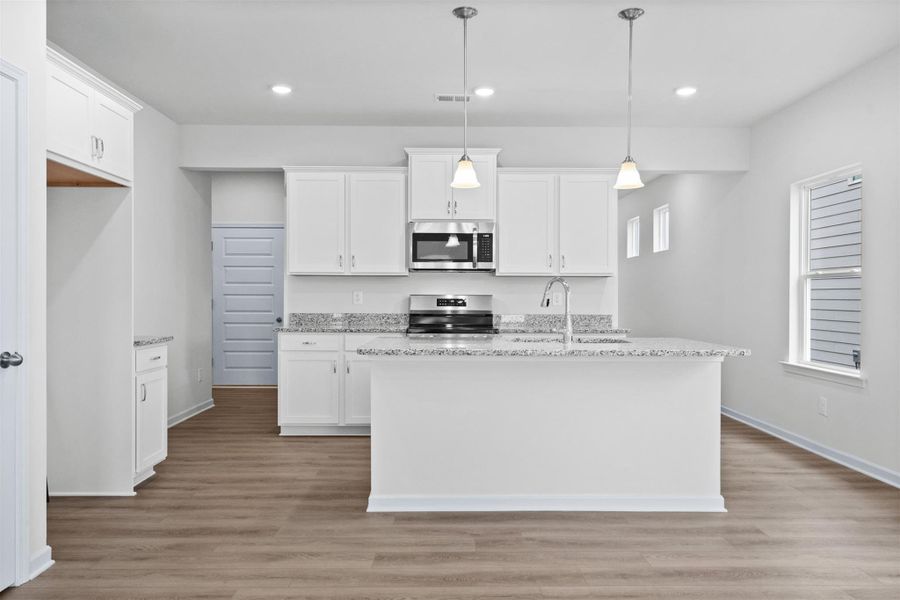 The Dove- Kitchen with Island. Home under construction, photo used for illustrative purposes only, colors and options will vary.