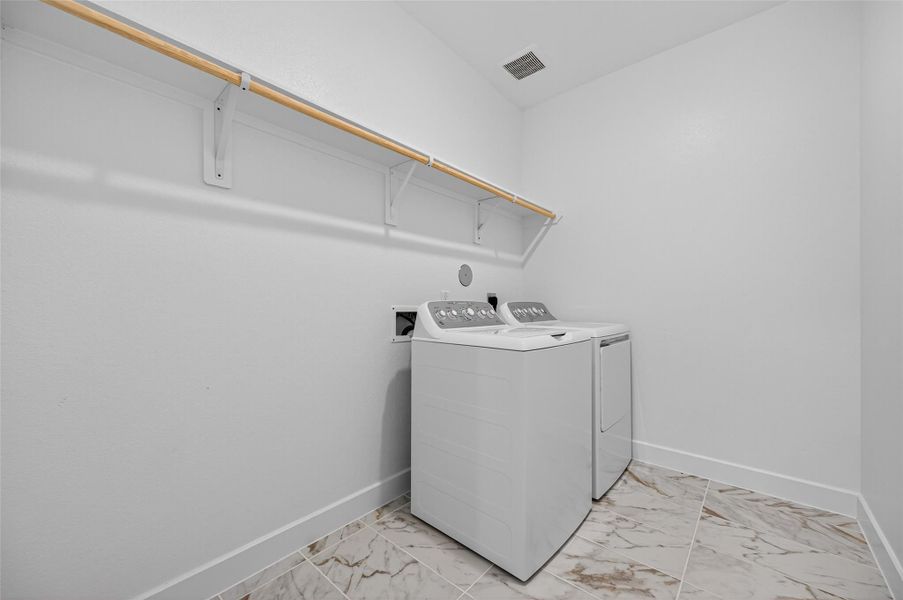 The utility room is bright and functional, featuring plenty of space for laundry needs and a convenient hanging shelf for organization.  This design makes daily tasks simple and efficient.