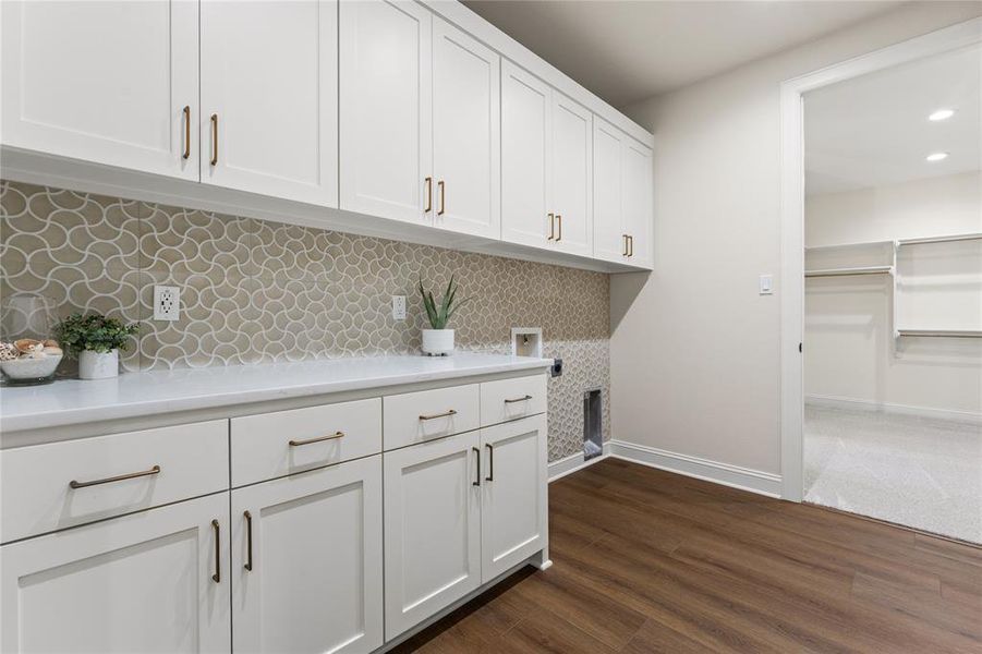 Laundry room featuring dark wood-style floors, recessed lighting, cabinet space, and washer hookup