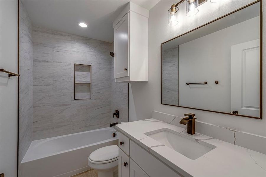 Bathroom featuring washtub / shower combination, vanity, toilet, and recessed lighting