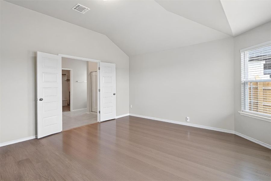 Tucked away at the very back of the home for maximum privacy, the primary suite features vinyl plank flooring, neutral toned walls and high ceiling Tucked away at the very back of the home for maximum privacy, the primary suite features vinyl plank flooring, neutral toned walls and high ceiling