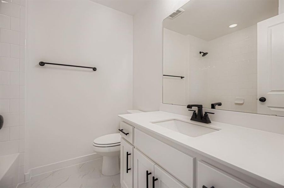 Full bath featuring vanity, light marble finish flooring,  shower combination, and recessed lighting