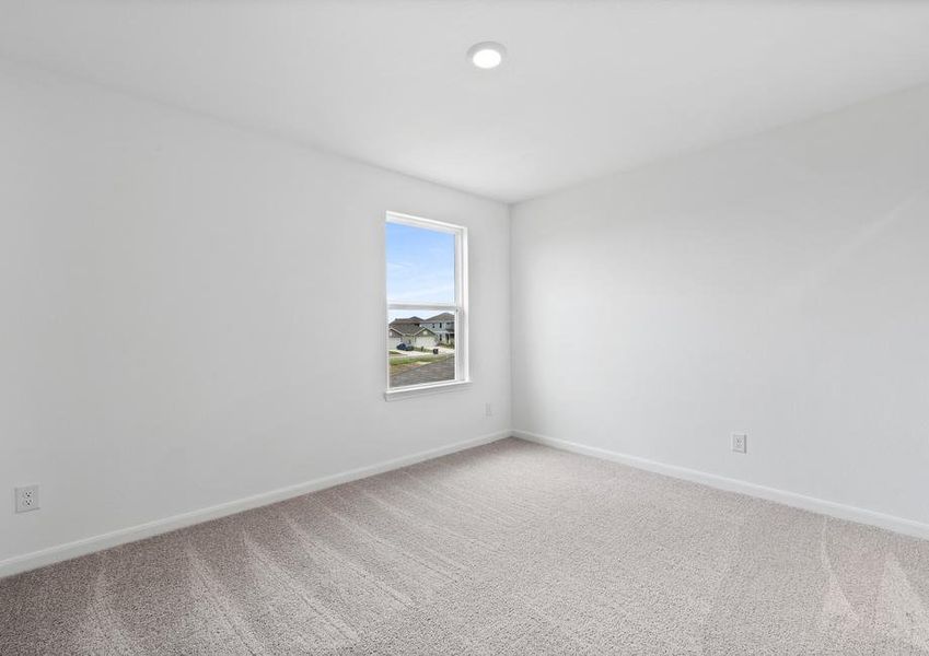 Secondary bedroom with a window and recessed lighting.